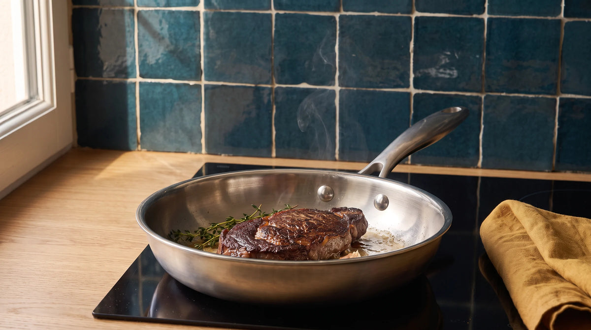 Filete de ternera dorándose en la sartén de acero inoxidable de 28 cm de Marthe, sobre una placa de inducción